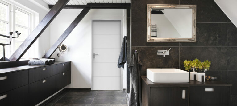 Bathroom in conjunction with bedroom. Structural beams, dark wood and granite tiles.